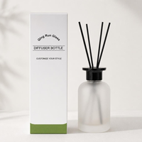 Bouteille diffuseur en verre dépoli rond avec bouchon noir et bâtonnets en rotin pour l'emballage de parfums d'intérieur