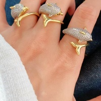 Cincin perhiasan statement chunky untuk wanita, dengan desain band emas melengkung yang saling menyatu dan band kristal pave.