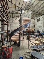 Escalier incurvé pour gagner de l'espace, Design avec marche en bois massif et balustrade en verre