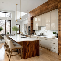 Meubles de cuisine modernes en placage de bois sur mesure avec portes brillantes, îlot central avec sièges et rangements hauts pour projets