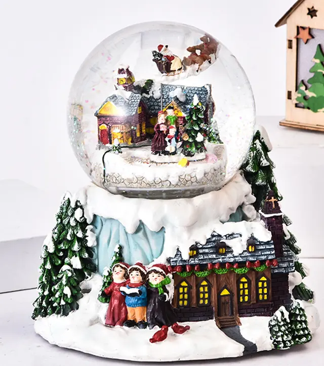 カラフルな装飾が施された青い山の装飾スノーグローブの上にクリスマススノーグローブ樹脂ガラスクリスタルボール