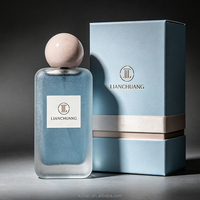 Flacon de parfum vide rectangulaire long givré bleu brumeux à paillettes, avec bouchon boule rose nude, plaque nominative blanche, logo personnalisé et coffret cadeau