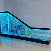 Paroi de séparation intérieure en panneau acrylique LED avec fontaine à bulles d'eau, motifs élégants et éclairage coloré