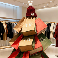 Sacs en papier kraft empilés de manière créative en forme de sapin de Noël, ajoutant une touche festive à l'affichage des magasins de vêtements