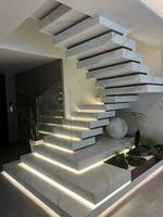 Escalier flottant empilé sur mesure avec garde-corps en verre, structure en bois durable et marches en bois massif pour les intérieurs de villas haut de gamme