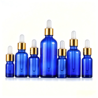 Vente en gros de flacons cylindriques en verre bleu anti-UV pour huiles essentielles, surface givrée, pipette compte-gouttes noire, col 18-415, personnalisable