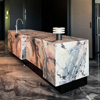 Îlot de cuisine moderne de luxe en marbre rose naturel du Portugal avec évier intégré, bord cascade et table de préparation avec armoire
