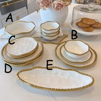 Service de table luxueux en céramique avec bordure dorée, assiettes, assiettes à fruits et à pâtisserie, assiettes à steak pour dîner occidental en hôtel.