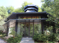 Maison en bois contemporaine avec un design géométrique et des murs en verre, idéale pour un hôtel boutique avec vue sur la mer ou la forêt