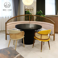 Ensemble de table et de chaises de café-restaurant en forme de demi-cercle, avec structure en bois rembourrée et plateau en pierre frittée noire ronde moderne