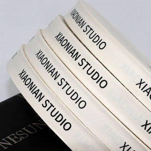ริบบิ้นผ้าฝ้ายรีไซเคิลพิมพ์ลายสีพื้นแบบกำหนดเอง 100% ขนาด 15 มม. สีขาวธรรมชาติ พร้อมโลโก้สำหรับของขวัญ - Product Image 1