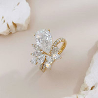 Anelli di fidanzamento da donna in oro giallo 18 carati con diamante coltivato in laboratorio, stile lusso leggero, con pietra centrale a goccia e cluster di diamanti.