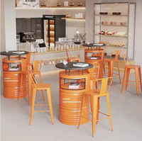 Table haute de style industriel moderne avec combinaison de chaises en forme de baril de gazoline pour utilisation en café ou comme mobilier de restaurant