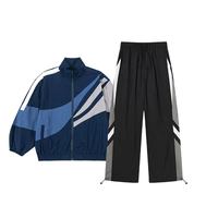 Ensemble survêtement streetwear pour homme : veste coupe-vent en nylon personnalisée avec logo brodé et patchwork, et pantalon baggy