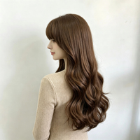 Porte une perruque bouclée brune chaude, accompagnée de franges légères et volumineuses. Convient pour un usage quotidien et des looks décontractés.