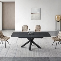 Table à manger en céramique de couleur béton avec deux panneaux coulissants extensibles et pieds croisés peints en poudre noire italienne