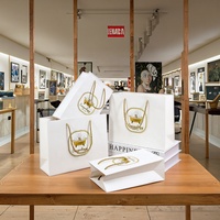 Sac de papier blanc de luxe imprimé de logo de haute qualité pour l'emballage cosmétique avec des poignées d'or
