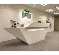 Comptoir de réception d'hôtel en surface solide avec un design audacieux de découpe triangulaire pour usage commercial
