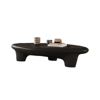 Table basse moderne noire mate, design organique irrégulier avec pieds sculpturaux épais