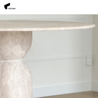 Table à manger ronde en travertin beige élégante de nouvelle conception Tostone avec pieds en forme de sablier pour les espaces à manger sophistiqués