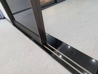 Portes coulissantes en verre télescopiques à fermeture douce sur mesure avec cadre doré, étanches et insonorisées pour l'élégance intérieure du salon