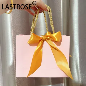 Hot sale luxury light pink packaging bag with ribbon private label recyclable cosmetic paper handbag