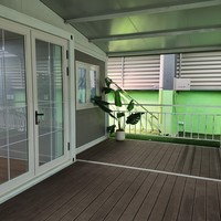 Maison conteneur extensible à bordure blanche 20 pieds, toit à pignon, couleur crème, 2 chambres, fenêtres à grille, porche, terrasse, cabane entièrement équipée