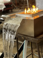 Fontaine d'eau décorative à flamme réelle pour piscine extérieure, au propane, avec texture et style.