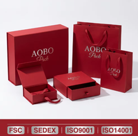 Boîte cadeau carrée en carton écologique, recyclable et biodégradable, avec logo rouge embossé personnalisé, finition mate premium et ruban.