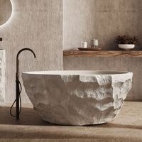 Baignoire autoportante artistique de style Wabi-sabi moderne et minimaliste, en pierre naturelle, avec détails en galets, capacité pour deux personnes