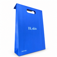 Sac en papier bleu Klein avec poignée découpée pour les boutiques de soins de la peau, les salons de beauté et les marques de cosmétiques, impression de logo personnalisée