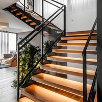 Villa de luxe intérieure avec escalier flottant moderne en arc, doté d'un cadre en acier, d' marches en bois et de garde-corps en verre trempé