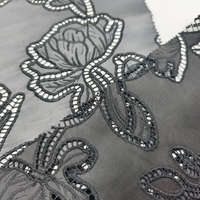 Tissu en cuir PU perforé brodé à découpe laser noire à motif floral abstrait pour manteau et textile de maison