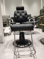 Fauteuil de barbier pliable en cuir synthétique noir, robuste, avec pompe hydraulique et repose-pieds réglable, pour salon commercial.
