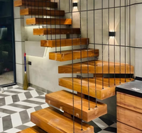 Escalier droit sur mesure de luxe, fabriqué avec des accents en nickel brossé et des marches larges, pour les lofts résidentiels haut de gamme