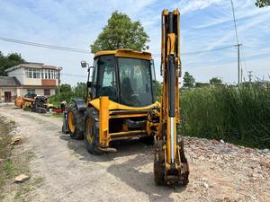 Chargeuse-pelleteuse JCB 4CX, moteur jaune, carrosserie noire, cabine avec intérieur rouge, siège rouge - Product Image 3