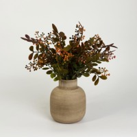 Bouquet de baies rouges artificielles et de feuillage en PE dans un vase brun côtelé