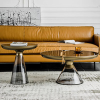 Table basse d'appoint moderne pour salon avec base conique en verre fumé, bordure en métal doré et dessus en verre noir
