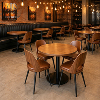Ensemble de meubles de luxe moderne pour restaurant, comprenant une chaise personnalisée Ron Group avec structure en bois, une table ronde et des banquettes en cuir noir.