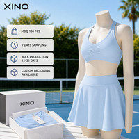 Ensemble de sport 2 pièces uni pour femme, avec brassière de sport dos nageur froncée à l'avant et jupe-short fluide taille haute avec short intégré, extensible dans quatre directions