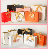 Tas Belanja Kertas Berlapis Dapat Didaur Ulang, Cetak Sablon Foil Emas, Desain Pita Timbul, Pegangan Pita, Tas Hadiah Kosmetik, Tas Belanja Fashion
