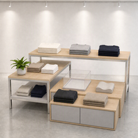 Ensemble de table de présentation à niveaux en MDF et acier inoxydable avec pieds fins noirs et armoire grise sur mesure