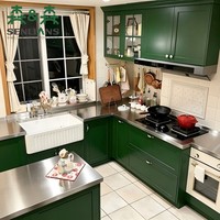 Meubles de cuisine avec évier blanc style ferme, robinet double poignée en laiton, portes Shaker vert foncé, en forme de U