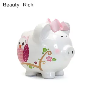动物陶瓷银行陶瓷存钱罐里的女孩，粉红色虚线猫头鹰