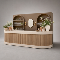Comptoir de bar événementiel modulaire arrondi en lattes de bois brun mat avec miroir ovale et appliques murales dorées pour location de mobilier de fête