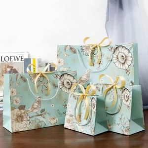 ถุงกระดาษช้อปปิ้งสีขาวขนาดใหญ่และกลาง พิมพ์ลายเต็มใบเคลือบลามิเนตแบบด้าน หรูหรา แข็งแรง ทนทาน สำหรับใส่เสื้อผ้า พร้อมโลโก้ - Product Image 1