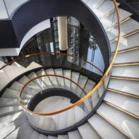 Escalier intérieur incurvé de luxe durable avec marches en acier et bois, design contemporain, personnalisable pour hall d'hôtel de luxe, manoir