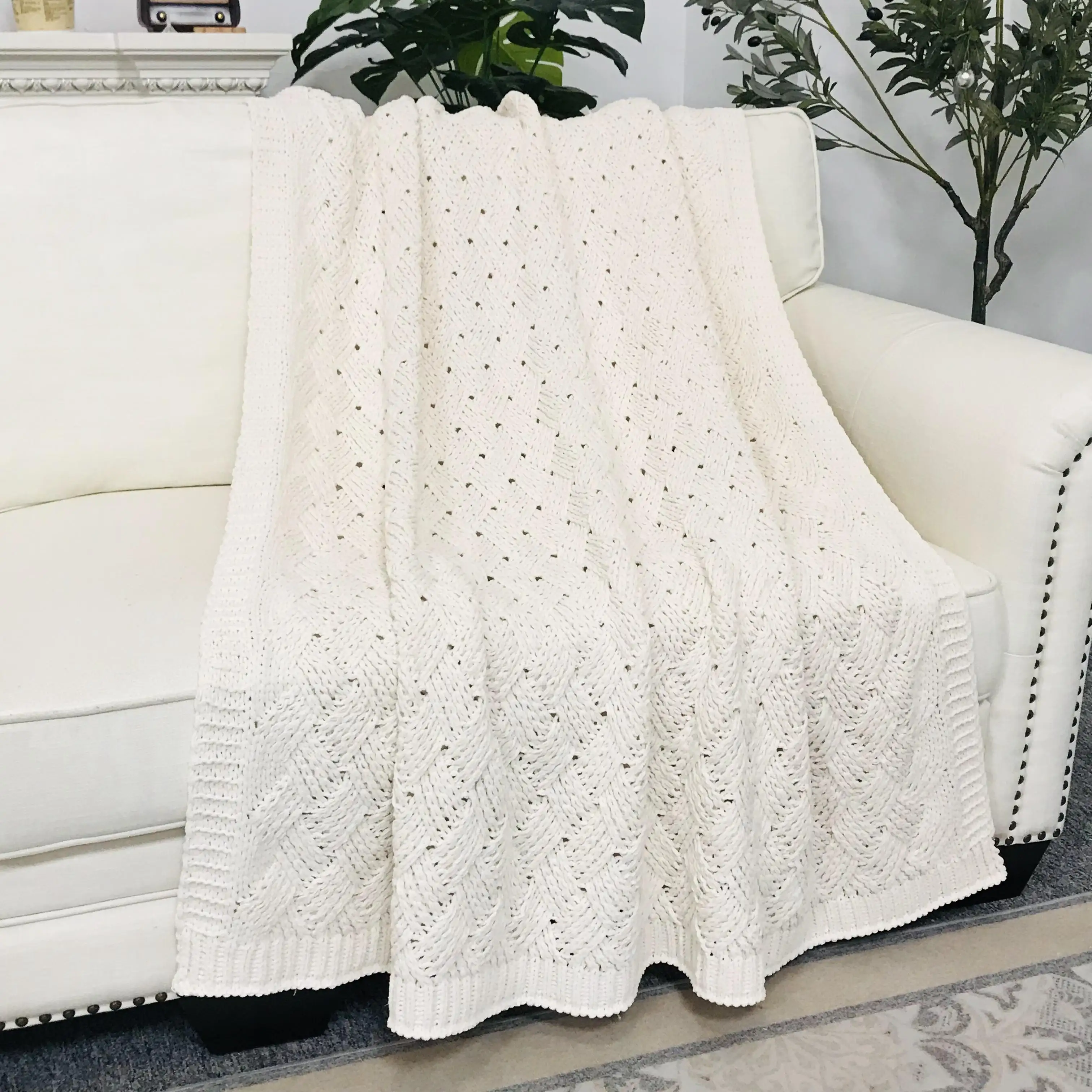 Soffice copriletto decorativo in ciniglia pesante e accogliente sul divano letto che appesantisce la coperta in maglia fatta a mano getta il soggiorno bianco