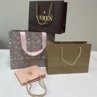 Vente en gros d'usine de sacs en papier rouge de luxe en carton avec poignée de ruban personnalisés Emballage cadeau imprimé durable pour vêtement