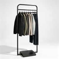 Porte-vêtements moderne minimaliste en métal noir avec cadre à coins arrondis et base lourde centralisée pour boutique de créateurs